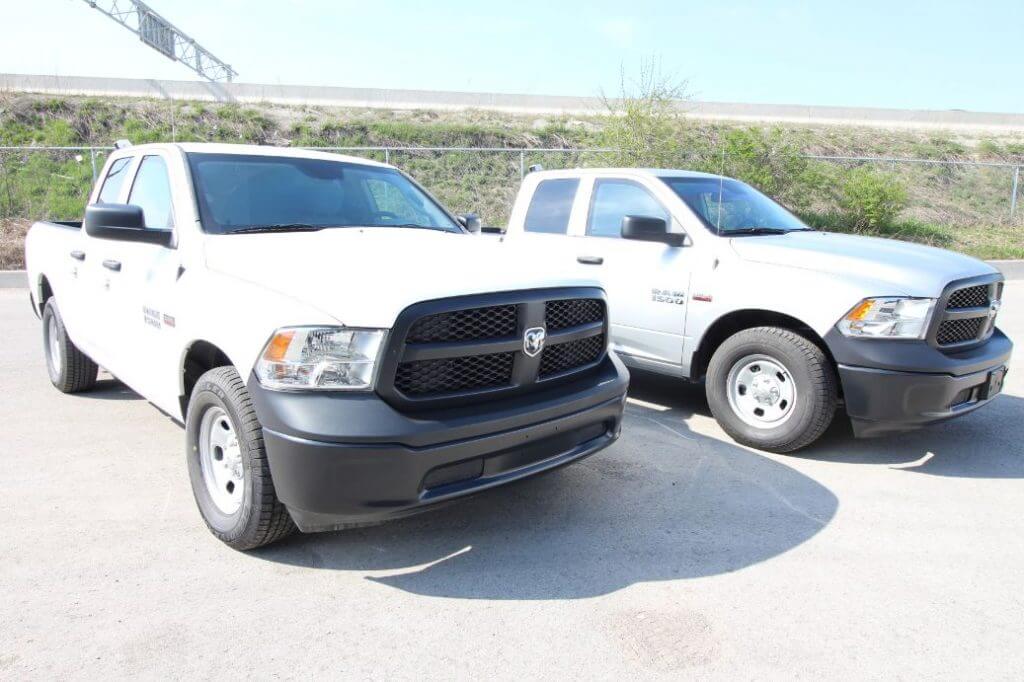 TAG Armored Dodge Ram 1500 Two White Trucks Parked Corner Side Front View Outdoors