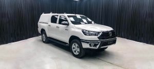 Alternate side view of white armored Toyota Hilux with a cap